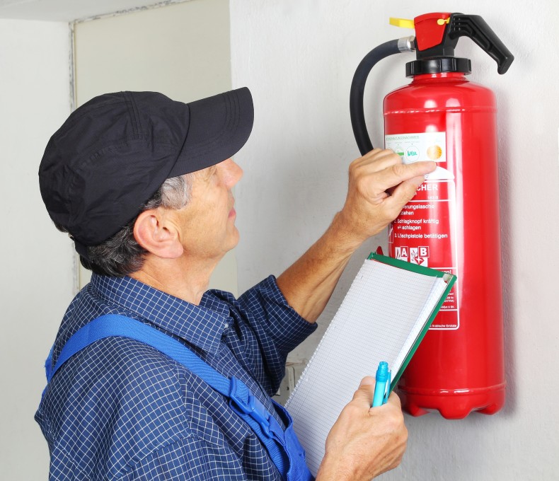 Eine Person prüft den Feuerlöscher. 